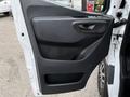 The interior side of a 2019 Mercedes-Benz Sprinter door featuring a textured black panel with a handle and a pocket at the bottom