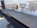 A close-up view of a metal truck bed with a diamond-patterned surface featuring several rusted fittings and mechanisms