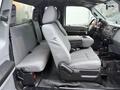 Interior of a 2015 Ford F-450 showing front and rear seats with gray fabric upholstery and a console in between
