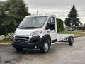 A white 2023 RAM Promaster 3500 with a cab and chassis design is parked on a street with a clear view of the front and side features of the vehicle