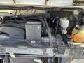 Close-up view of the engine compartment of a 2012 Ford Econoline showing various engine components and fluids