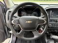 Steering wheel of a 2017 Chevrolet Colorado with a Chevrolet logo and control buttons visible in the foreground