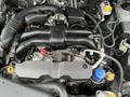 Close-up view of the engine of a 2016 Subaru Forester showcasing the intake manifold and various components including hoses and caps