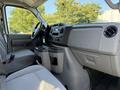 Interior view of a 2021 Ford Econoline showing the driver's seat and dashboard with controls and cup holders
