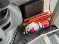 A red fire extinguisher and orange safety triangles are placed on the floor of a vehicle near the entrance