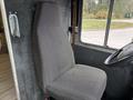 A gray fabric driver's seat inside a 2012 Ford E-450 Super Duty with a steering wheel visible in the foreground
