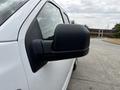 Close-up of the side mirror of a white 2018 Ford F-150 showing the black housing and sleek design features