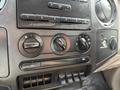 The dashboard controls of a 2008 Ford F-450 including climate control knobs and auxiliary ports