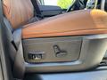 Close-up of the driver's seat adjustment controls in a 2015 RAM 1500 featuring leather upholstery in brown and black