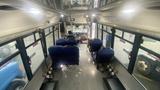 Interior view of a 2021 Ford Transit with blue seating and a driver area visible at the front