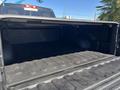 A 2015 RAM 1500 truck bed with a lined interior and an open tailgate displaying a clean and spacious cargo area