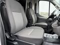 Two gray seats inside a 2022 Ford Transit van with a simple design and fabric upholstery