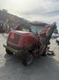 A red 2013 Toro Grounds Master 5910 lawn mower with an inclined cutting deck and large rear wheels is parked with its cutting deck raised