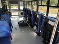 Interior view of a 2020 Chevrolet Express featuring blue seats and a secured tire in the aisle