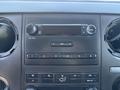 Dashboard of a 2011 Ford F-550 featuring a radio with buttons for audio control and air conditioning dials
