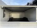 Interior of a 2010 Ford F-550 utility truck showing an empty cargo area with metal racks and supports along the walls