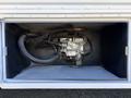 A 2013 International CE300 engine compartment displaying various hoses and mechanical components in a darkened space