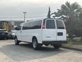 A white 2021 Chevrolet Express van parked with a large rear window and chrome wheels