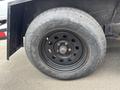 A black wheel with a circular design featuring multiple holes and a visible tire number on the sidewall