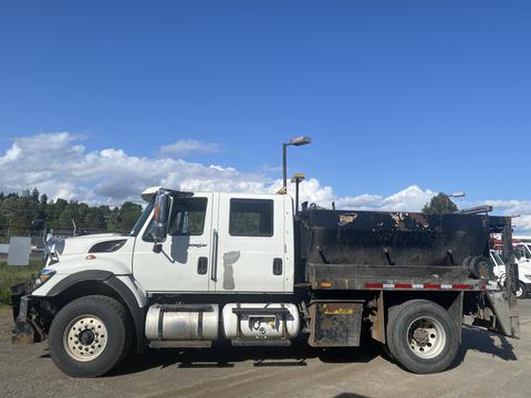 A white 2014 International 7400 truck with a black dump bed equipped for hauling and transporting materials