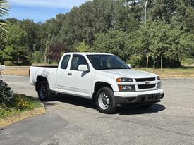 A white 2011 Chevrolet Colorado pickup truck parked at an angle with a cab and bed designed for utility and transportation