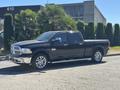 A black 2015 RAM 1500 with chrome accents parked on the street featuring four doors and stylish alloy wheels
