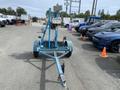 A blue 2003 U-Built Reel Trailer featuring a central support pole with a mounted control box and reel mechanism at the front