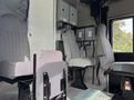 Interior of a 2020 Freightliner MT45 showing gray seats arranged in a row with seatbelts visible and control panels mounted on the wall