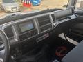 Interior view of a 2012 Hino 338 with a dashboard featuring a touchscreen display and various controls including climate settings and a no smoking sign