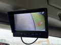 A 2015 Ford Econoline displayed on a rearview camera monitor showing a view of the ground outside with a traffic cone visible
