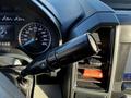 Close-up of a 2020 Ford F-350 gear shift lever with a control for drive mode and dashboard displaying speed and various indicators