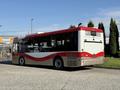 A 2016 Grande West Vicinity bus in red and white with a sleek design parked on a concrete surface