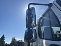 A 2022 Freightliner M2 106 truck with a focus on its chrome side mirror and window reflecting sunlight