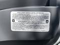 2022 Isuzu NRR with a vehicle noise emission control information label displayed prominently in the foreground