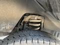 Close-up of the suspension system of a 2012 Ford Econoline showing a coil spring and part of the tire tread