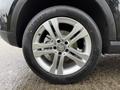 Close-up of a silver alloy wheel featuring the Mercedes-Benz logo and a black tire with detailed tread pattern