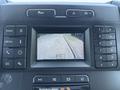 Dashboard display of a 2019 Ford F-150 showing a rearview camera view of a paved road with trees along the side