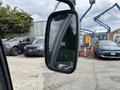 A 2019 Madvac LS175 mirror reflecting parked vehicles and machinery in the background