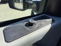 Close-up of the interior of a 2012 Ford F-350 SD showing a black control knob on a textured panel near the window with some dust accumulated on the surface