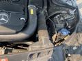 Engine compartment of a 2013 Mercedes-Benz C-Class showing the air intake hose and various mechanical components
