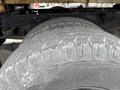 A close-up of a heavily worn tire from a 2004 Ford F-350 SD showcasing deep treads and signs of significant use