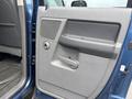 Interior door panel of a 2006 Dodge Ram 2500 featuring a handle speaker grille and window controls
