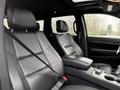 Interior of a 2019 Jeep Grand Cherokee showing two leather front seats with armrest and seatbelt in view