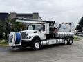 A 2013 International Workstar 7500 vacuum truck with a large tank and hose system mounted on the chassis designed for industrial cleaning and waste removal