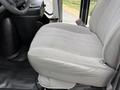 A gray fabric driver seat of a 2013 Chevrolet Express with a smooth surface and padded design