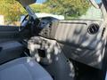 Interior view of a 2019 Ford E-450 showing the dashboard and front seats with cup holders and controls