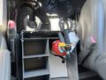 A 2013 Chevrolet Express with a fire extinguisher secured inside a storage box on the floor between the front seats