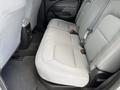 The image shows the rear seating area of a 2018 Chevrolet Colorado with gray fabric seats and seat belts visible