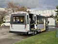 A 2019 Chevrolet Express shuttle bus with a ramp extended for accessibility and a rear entrance visible