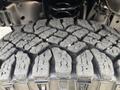 Close-up of a textured tire tread from a 2013 Ford E-350 Super Duty showing deep grooves and rugged patterns designed for traction and durability